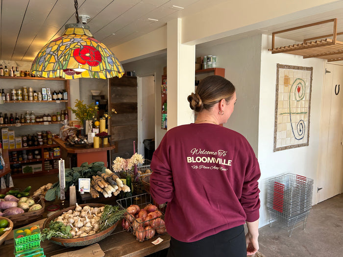 Welcome to bloomville text on back of maroon crew sweatshirt