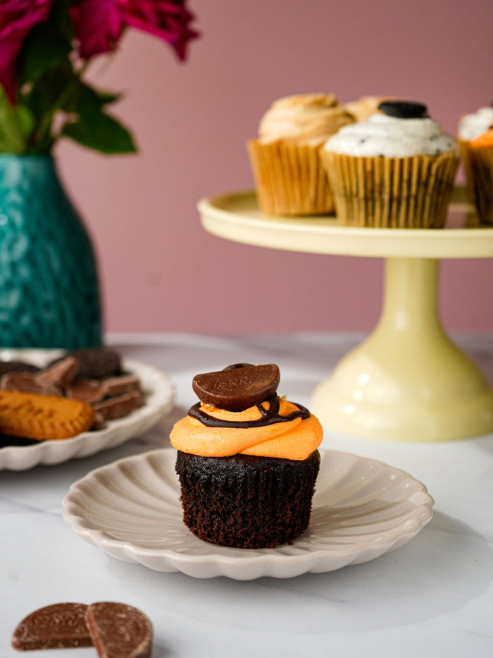 Chocolate orange cupcake with orange buttercream and a chocolate disc on top