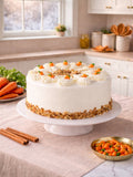 Carrot Cake in cream cheese frosting on a kitchen table with fresh carrots and cinnamon