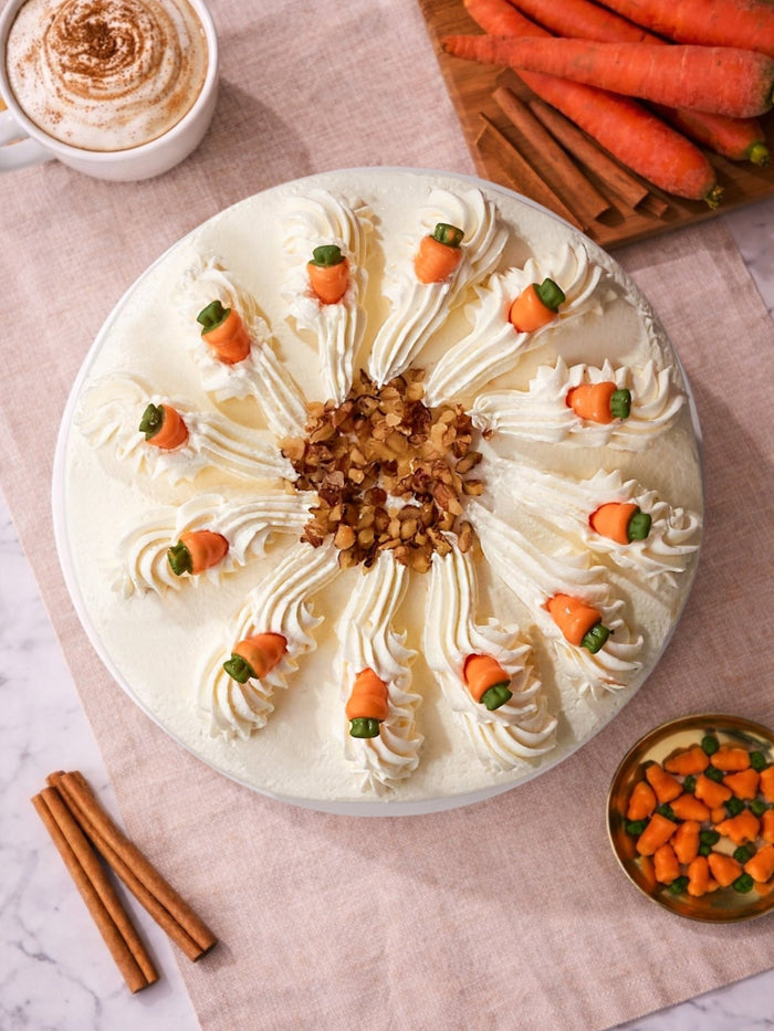 Overhead view of the carrot cake, piped frosting with marzipan carrots around a nutty centre