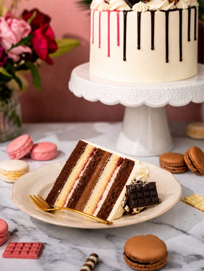 Slice of the half and half drip cake showing alternating chocolate and vanilla sponge layers