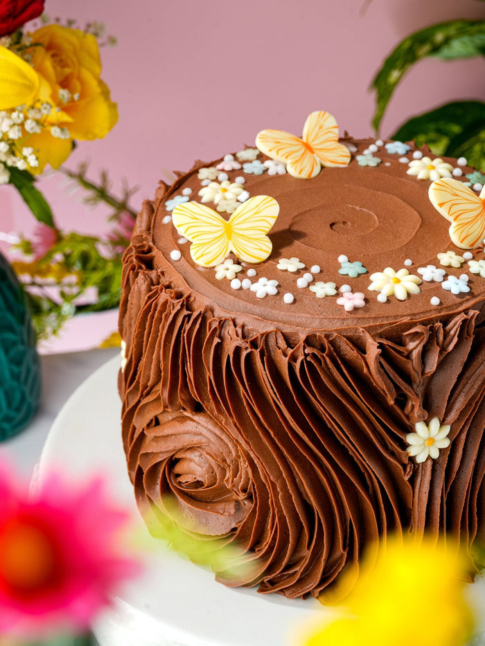 Close view of the sugar butterflies and blossoms decorating the top of the chocolate cake