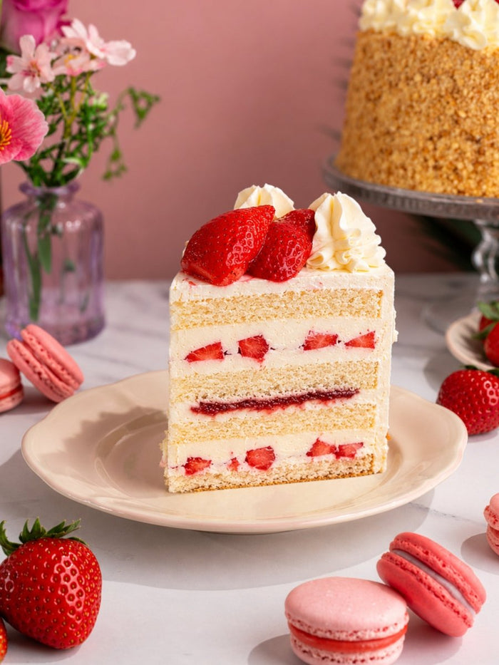 Slice of strawberry gateau showing layers of light sponge, fresh cream and strawberries
