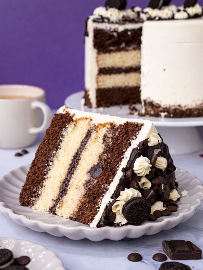 Slice of Cookies and Cream Cake showing its chocolate and vanilla sponge layers