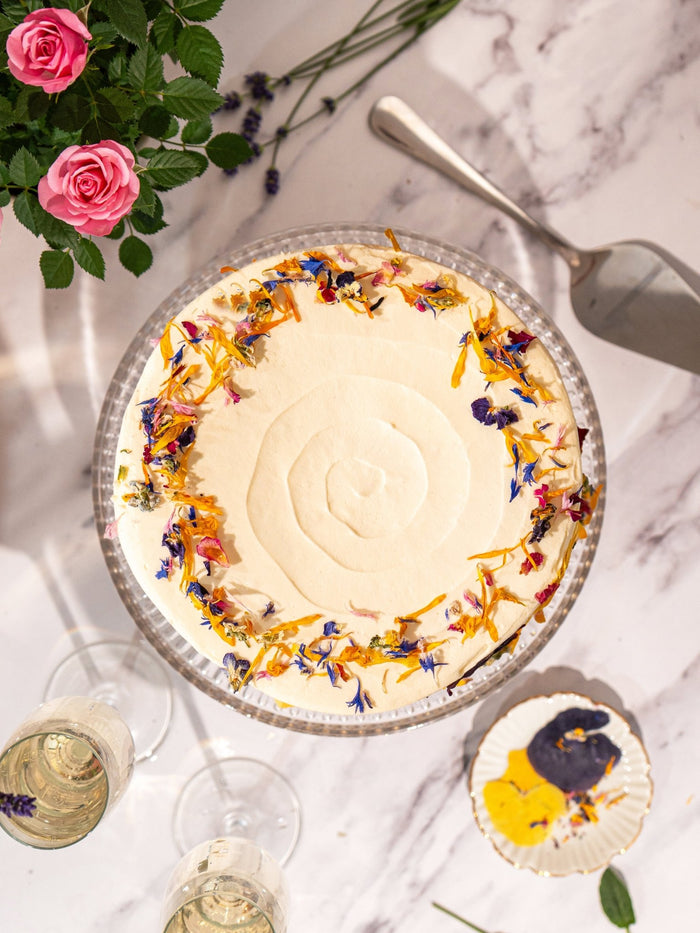 Overhead view of the elderflower and rose cake, a border of edible petals around a swirled top