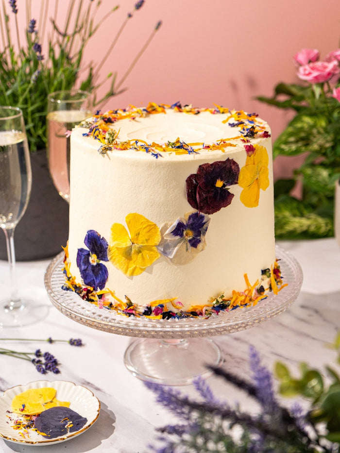 Close view of the pressed pansies and petals set into the buttercream of the garden cake