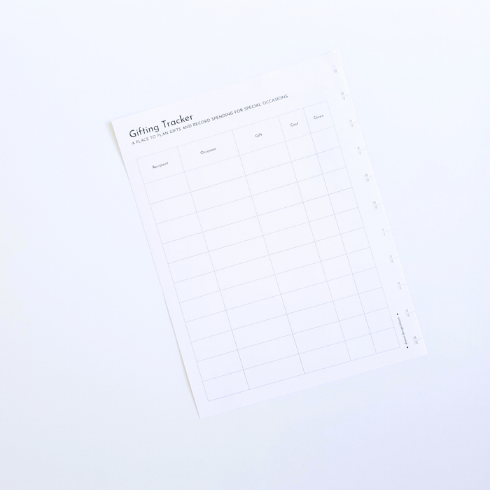 A white gift tracker discbound planner insert with a minimalist grid layout and black text, photographed at an angle on a clean white background. Disc Bound Planner.