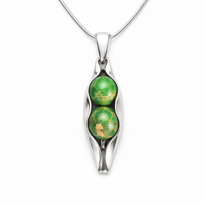 Silver pendant with green gemstones on a white background