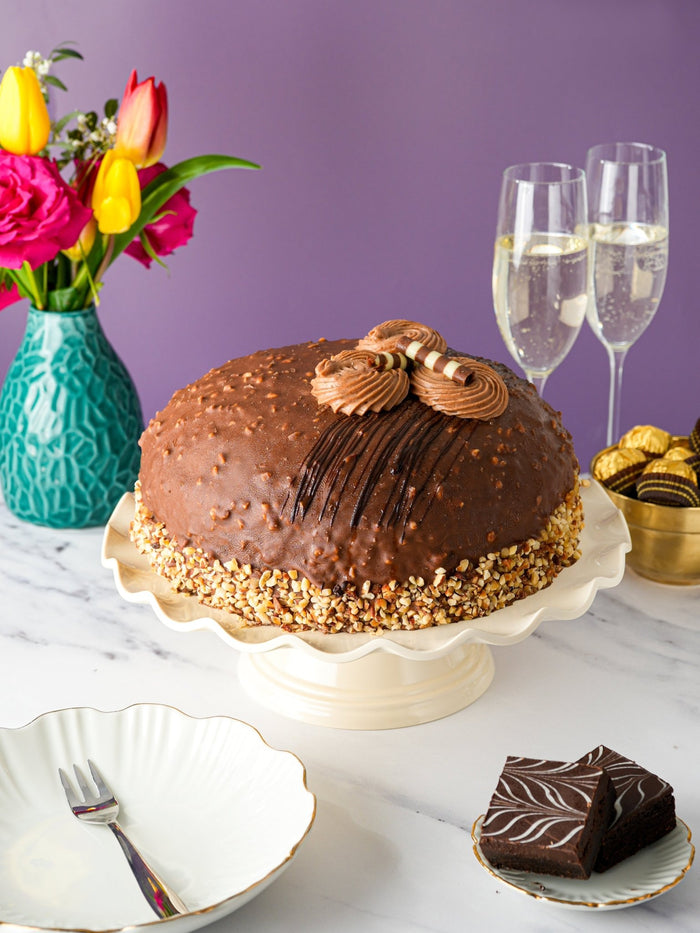 Luxury Nutella Crunch Dome Cake with a chopped hazelnut base and piped chocolate cream on top