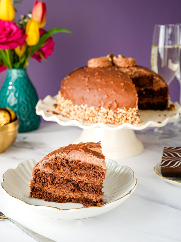 Nutella crunch dome cake with a slice cut to reveal its chocolate sponge and hazelnut cream layers