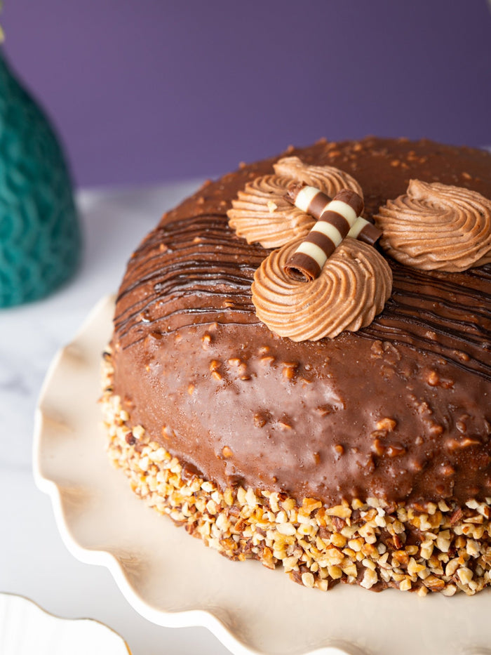 Close view of the domed chocolate glaze, piped rosettes and chocolate curl on the dome cake