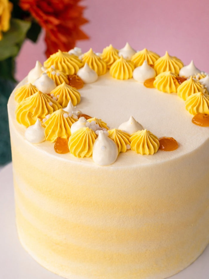 Close view of the piped mango cream and meringue kisses on top of the cake