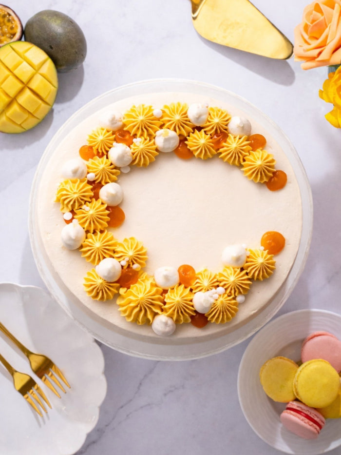 Overhead view of the Mango and Passionfruit Cake, a crescent of piped fruit cream on top