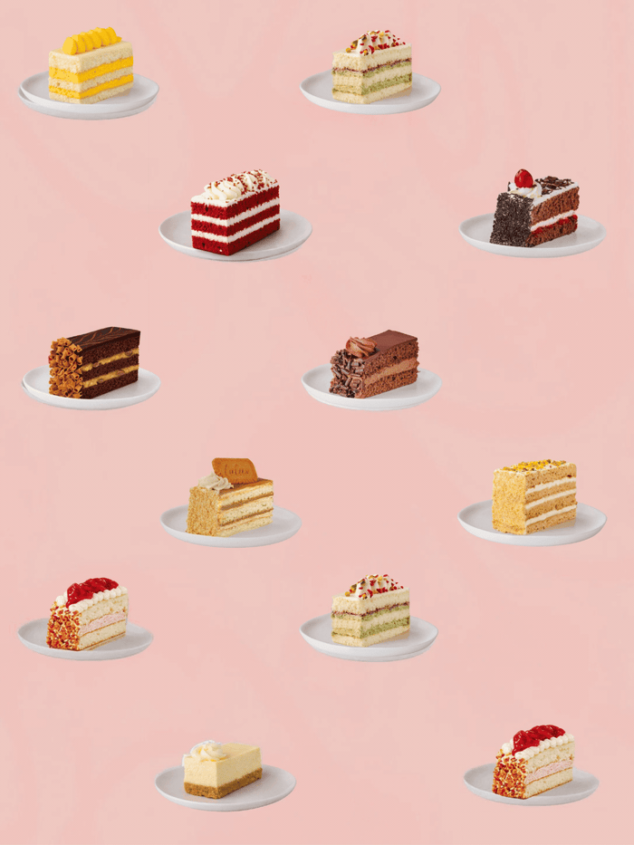 Pick and mix spread of cake slices, from red velvet to mango and chocolate, on a pink background