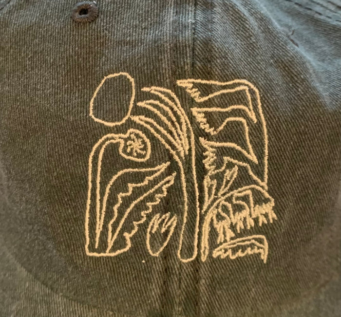 Zoomed in detailed shot of green baseball hat with an abstract floral design and text on the front
