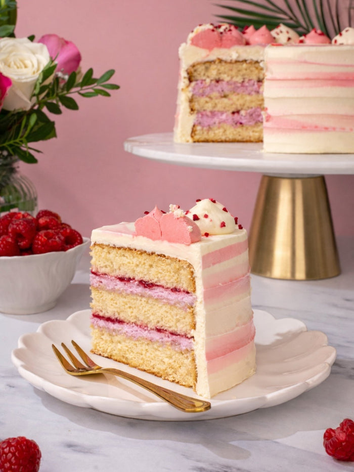 Slice of raspberry ripple cake showing raspberry cream between soft vanilla sponge layers