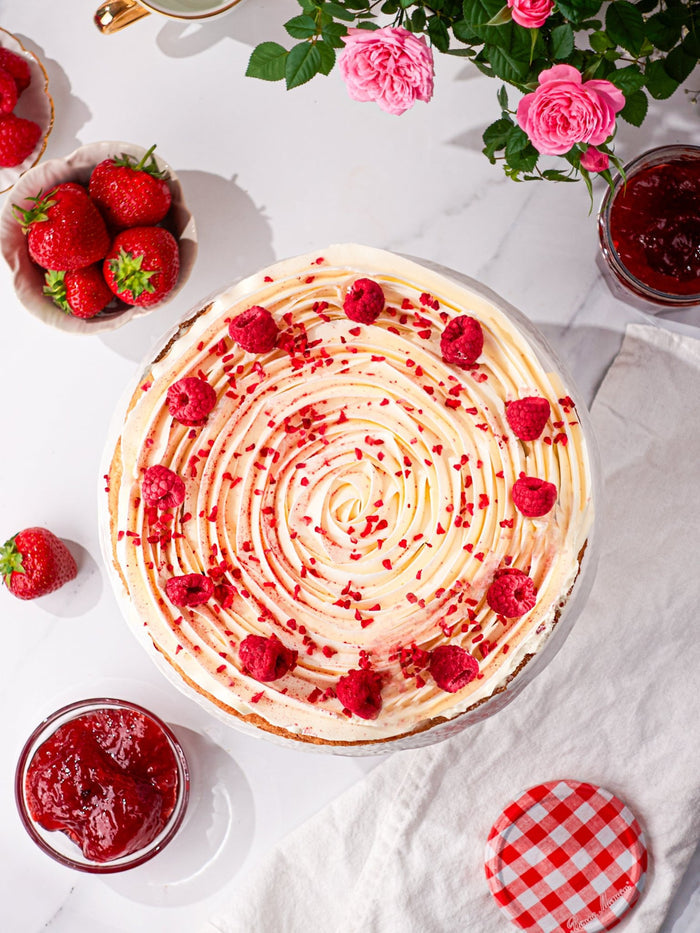 Overhead view of the Victoria sponge, a piped cream spiral topped with fresh raspberries